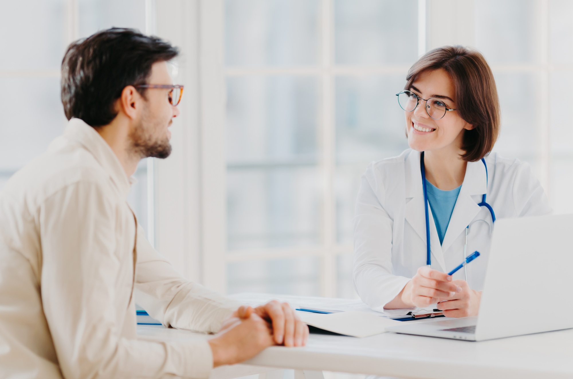 Attentive female doctor explains diagnosis to patient, gives professional consultancy